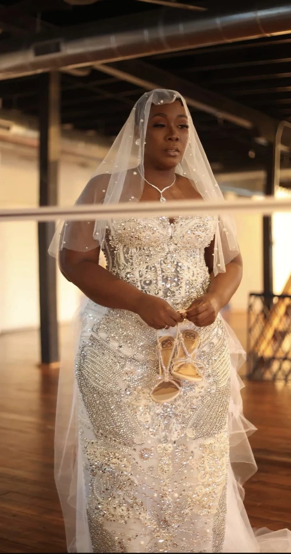 Bride wearing a crystal embellished JhéneAlorá gown and pearl veil