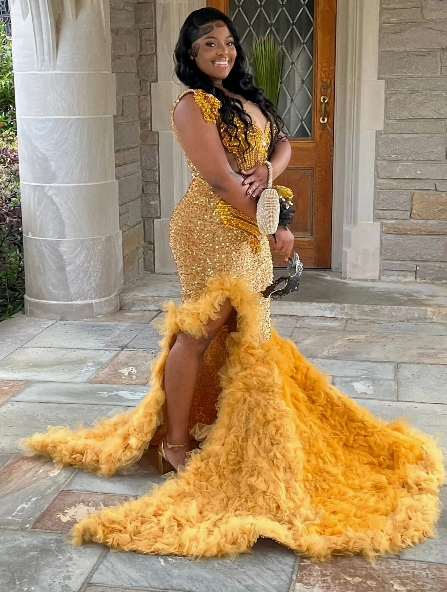 Client wearing a gold crystal gown with a full ruffled train
